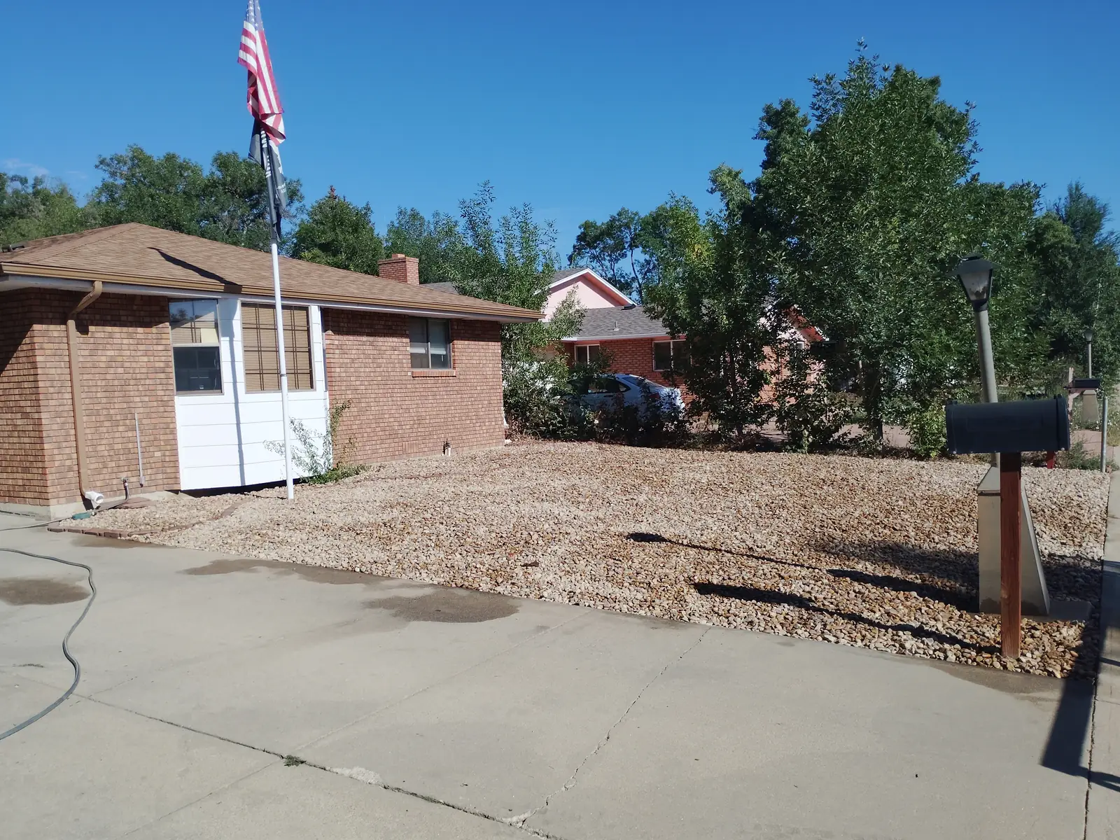 After: River rock bed spread across the front yard between the driveway and walkway in Longmont, CO